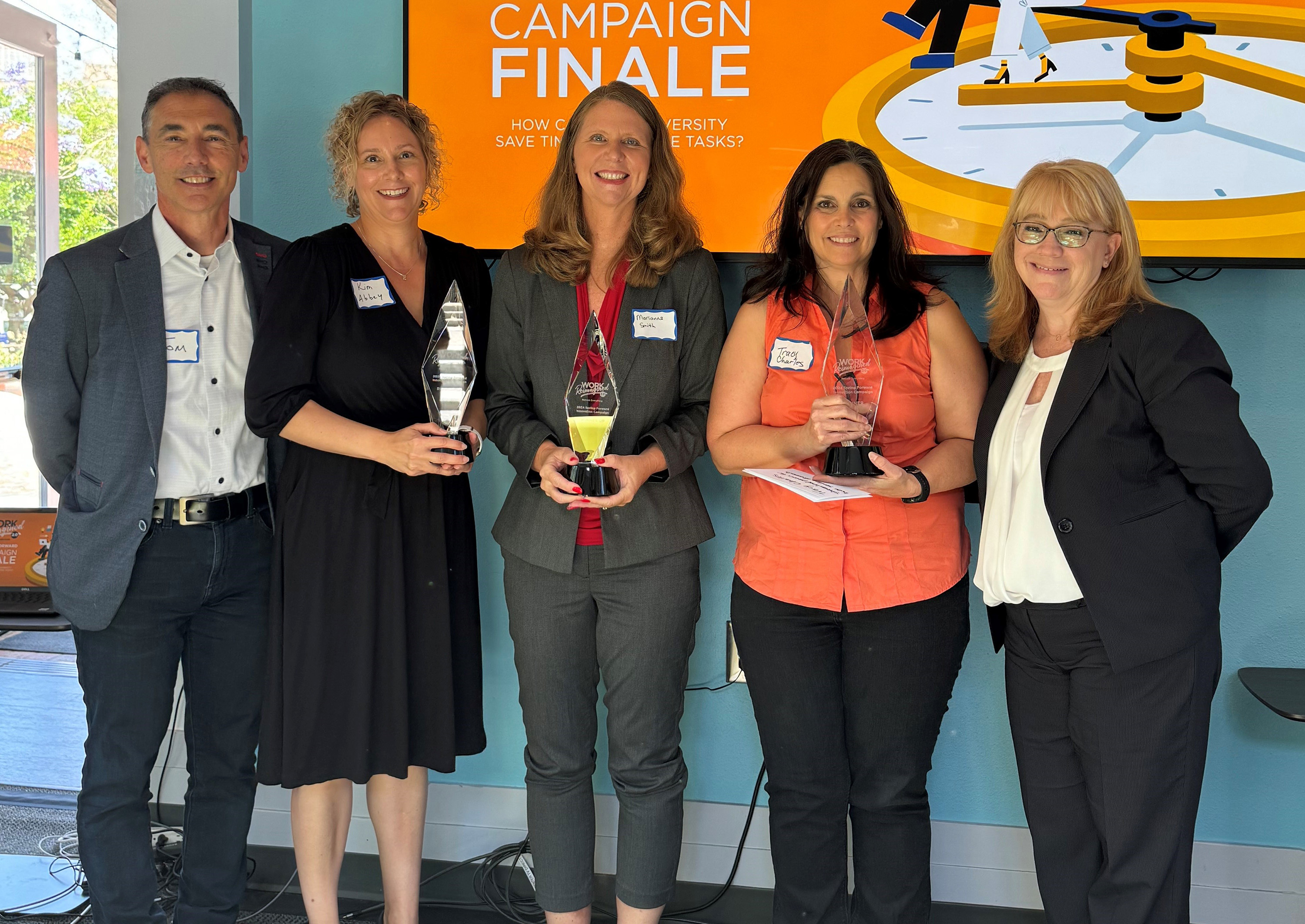 Spring Forward participants (left to right) Kim Abbey, Marianne Smith, and Tracy Charles hold their awards next to Tom Andriola and Ramona Agrela