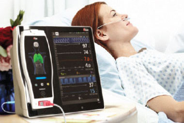 patient in hospital bed with bedside monitor
